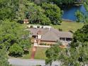 Aerial view of a single-story brick house with an in-ground pool and lake view at 29 Windsor Isle Dr, Longwood, FL 32779