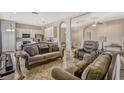 Spacious living room featuring tile flooring, comfortable seating, and an open floor plan to the kitchen at 115 Crescent Moon Dr, Groveland, FL 34736