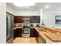 Well-equipped kitchen with stainless steel appliances, rich wood cabinetry, and granite countertops at 1375 Tuscana Ln # 1408, Davenport, FL 33896