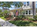 Beautiful home with an inviting front porch, lush landscaping, and a welcoming American flag at 14838 Bahama Swallow Blvd, Winter Garden, FL 34787