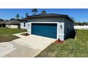 Charming single-story home featuring a modern design, blue garage door and well-manicured lawn at 15750 Sw 40Th Ter Sw 40Th Ter, Ocala, FL 34473