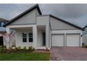 Beautiful modern home featuring a brick driveway, a two-car garage, and gray-and-white paint at 16271 Silver Grove Blvd, Winter Garden, FL 34787
