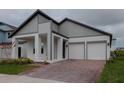Beautiful modern home featuring a brick driveway, a two-car garage, and gray-and-white paint at 16271 Silver Grove Blvd, Winter Garden, FL 34787