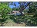 Expansive backyard with mature trees, a lush lawn and a charming patio at 1635 Magnolia Ave, South Daytona, FL 32119