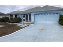 Inviting single-story home with a two-car garage and a beautifully painted driveway at 1805 San Luis Ln, The Villages, FL 32159