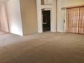 Spacious living room featuring neutral carpeting and a view into another room at 1805 San Luis Ln, The Villages, FL 32159