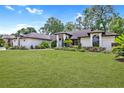 Charming home showcasing a pristine lawn, mature trees, and a freshly painted white brick exterior at 216 Shady Oaks Cir, Lake Mary, FL 32746