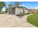 Spacious three-car garage, white brick exterior, with a concrete driveway and lush green landscaping at 216 Shady Oaks Cir, Lake Mary, FL 32746
