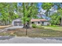 Lovely single-story house with a gray two-car garage, blue door and large trees in a well-kept yard at 217 E Hillcrest St, Altamonte Springs, FL 32701
