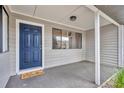 Covered front porch with a blue door, gray siding, and a charming 'Welcome' mat at 217 E Hillcrest St, Altamonte Springs, FL 32701