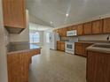 Spacious kitchen with wooden cabinetry, white appliances, and an adjoining dining area at 224 Lake Charles Dr, Davenport, FL 33837