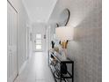 Bright hallway with tiled floors, console table with lamp, and decorative wallpaper at 2400 Reading Trl, Kissimmee, FL 34746