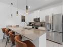Modern kitchen featuring stainless steel appliances, a large island with bar stool seating, and pendant lighting at 2400 Reading Trl, Kissimmee, FL 34746