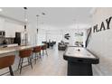 Open-concept living space with modern kitchen, dining area, and entertainment area with an air hockey table at 2400 Reading Trl, Kissimmee, FL 34746