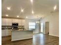 Open-concept kitchen features white cabinets, granite counters, island, and stainless steel appliances at 2607 Tulip Dr, Davenport, FL 33837