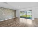 Open living room featuring a decorative tile accent wall and sliding glass doors to the backyard at 2730 Parkfield Rd, St Cloud, FL 34772
