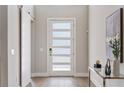 Bright foyer featuring a glass-paneled front door, hardwood floors, and modern decor at 2813 Northwood Blvd, Winter Park, FL 32789