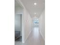 Bright hallway featuring recessed lighting and sleek wood-look flooring leading to various rooms at 349 Guadlupe St, Haines City, FL 33844