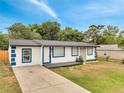 Well-maintained single-story home boasting a white stucco finish and a concrete driveway at 358 Prevo Dr, Apopka, FL 32712