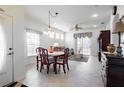 Bright dining area with decorative chandelier, tile floors and abundant natural light from large windows and sliding door at 401 Harbor Winds Ct, Winter Springs, FL 32708