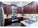 Modern kitchen boasting dark wood cabinets, stainless steel appliances, granite countertops and tile backsplash at 401 Harbor Winds Ct, Winter Springs, FL 32708