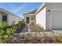 Landscaped front yard showcasing walkway to front door and a lush garden at 4224 Pebbles Throw Dr, Kissimmee, FL 34746