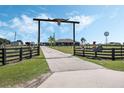 Ranch-style entrance with longhorn skull overhead leading up a long driveway to the gray ranch home at 4400 Walker Lake Rd, Bartow, FL 33830