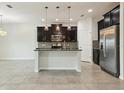 Modern kitchen with granite countertops, stainless steel appliances, dark wood cabinets, and a center island with pendant lighting at 611 Marsh Reed Dr, Winter Garden, FL 34787
