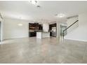 Spacious living room featuring tile floors, an open layout, modern light fixtures, and a view into the adjacent kitchen at 611 Marsh Reed Dr, Winter Garden, FL 34787