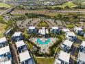 Expansive aerial view showcases a condo community, pool, and a parking lot near highway and surrounding neighborhoods at 7770 Sandy Ridge Dr # 207, Reunion, FL 34747