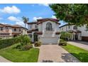 Beautiful two-story home boasts a lush front yard with palm trees and a brick driveway at 8125 Via Rosa, Orlando, FL 32836
