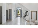 Bright foyer with high ceilings, marble floors, and staircase with black railing at 8125 Via Rosa, Orlando, FL 32836