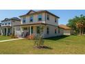 Charming two-story home with a cozy front porch, rocking chairs, and well-maintained landscaping at 900 S Maple Ave, Sanford, FL 32771