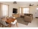 Bright living room featuring a comfortable sectional sofa, large TV, and elegant dining set at 900 S Maple Ave, Sanford, FL 32771