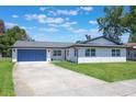 Charming single Gathering home with a blue garage door and a well manicured lawn on a sunny day at 1148 Martin L King Dr, Orlando, FL 32805