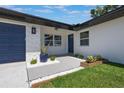 Inviting front exterior showcasing a well-maintained lawn and a modern design with a blue front door at 1148 Martin L King Dr, Orlando, FL 32805