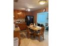 Traditional kitchen area featuring wood cabinets, dark appliances, a dining area, and plenty of natural light at 116 E Palm Way, Edgewater, FL 32132