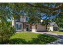 Inviting home front with a stone facade, an attached two-car garage, and lush green lawn at 13247 Hatherton Cir, Orlando, FL 32832