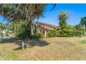 Side view of a two-story home showcasing mature landscaping and lush greenery at 1450 Harbour Dr, Longwood, FL 32750