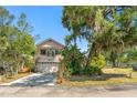 Two-story home with balcony and two-car garage surrounded by lush trees at 1450 Harbour Dr, Longwood, FL 32750