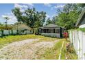 Charming one-story home with a gravel driveway, surrounded by mature trees and lush greenery at 1506 37Th St, Orlando, FL 32839