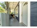 Inviting front porch with a decorative door, gray wood siding and cozy seating area at 1506 37Th St, Orlando, FL 32839