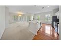Open-concept living room with carpet, wood flooring, and doors leading to the outside at 1630 Common Way Rd # 303, Orlando, FL 32814