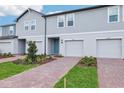 New townhome boasts brick paver driveway, landscaping, and stylish facade at 16447 Bird Of Paradise Ave, Clermont, FL 34714