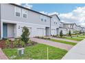 New townhome features brick paver driveway, green space, and appealing facade at 16447 Bird Of Paradise Ave, Clermont, FL 34714
