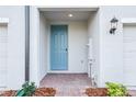 Charming front porch with brick pavers and a blue front door at 16447 Bird Of Paradise Ave, Clermont, FL 34714