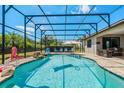 Sparkling screened-in pool with waterfall feature, lounge chairs and patio area perfect for outdoor entertaining at 17106 Guilford Ct, Orlando, FL 32820
