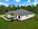 Beautiful aerial of a modern single-story home with manicured lawn and natural surroundings under a bright blue sky at 18026 Reynolds Pkwy, Orlando, FL 32833