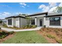Charming home featuring dark trim windows, a well-manicured lawn, and sidewalk at 18026 Reynolds Pkwy, Orlando, FL 32833