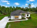 An eye-level aerial view shows an appealing one-story home with green lawn and natural surroundings under a blue sky at 18026 Reynolds Pkwy, Orlando, FL 32833